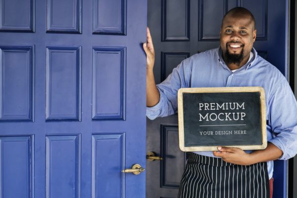 实木材质黑板框架真人演示样机素材 Man holding Open Sign Mockup