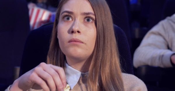 女生影院观看爆米花电影剪影视频素材 Girl Frowns at the Movie Theater