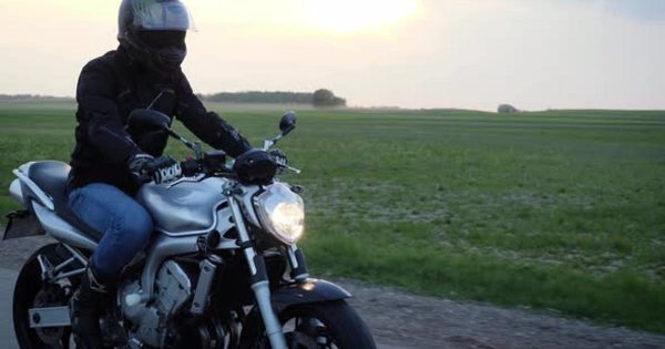 摩托车机车骑行者视频素材 Biker Riding Motorcycle On The Road During Sunset