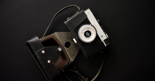老式复古胶卷相机黑色大洋岛精选背景视频素材 Old Retro Film Camera in Leather Case on Black Background